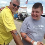 Peter, the Roasted Corn vendor and Cody showing off their AutismAwarenessShop.com tattoos